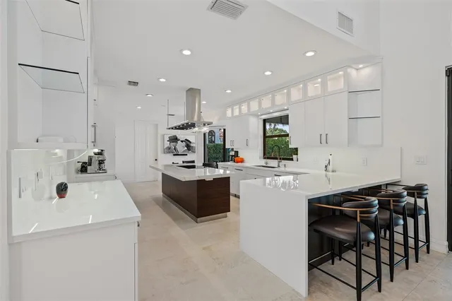 a kitchen with kitchen island a stove a table and chairs in it