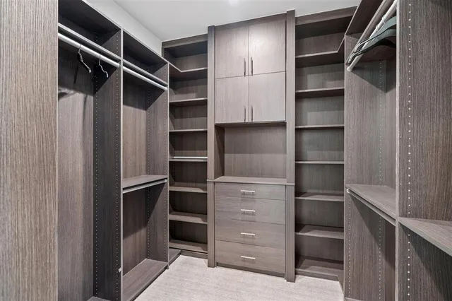 a view of walk in closet with empty racks