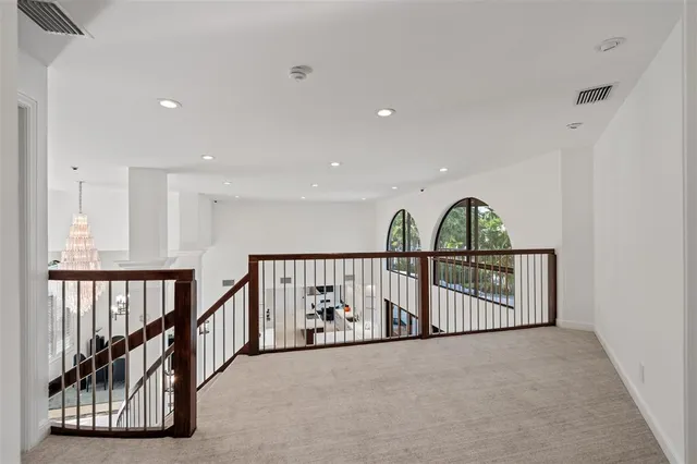 a view of staircase with railing and a chandelier