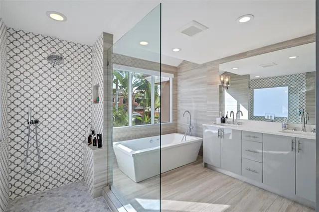 a bathroom with a sink tub granite and a glass door shower