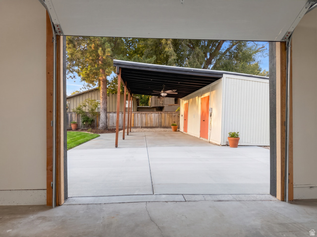 1860 Spring Lane Holladay, UT 84117 - Photo 27 of 32 Spacious concrete patio with an attached covered structure, featuring a ceiling fan and exterior lighting