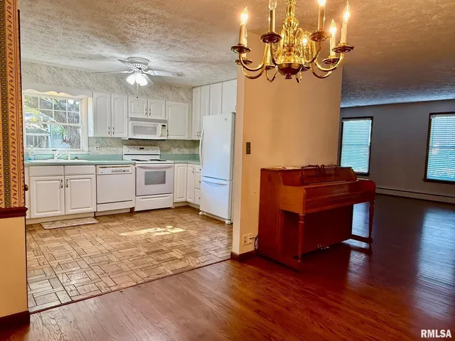 a kitchen with stainless steel appliances granite countertop a refrigerator a stove top oven and a dishwasher next to a window