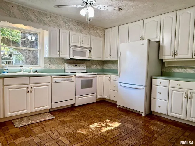 a kitchen with cabinets stainless steel appliances and a window