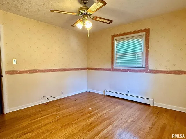 a view of a room with wooden floor and fan