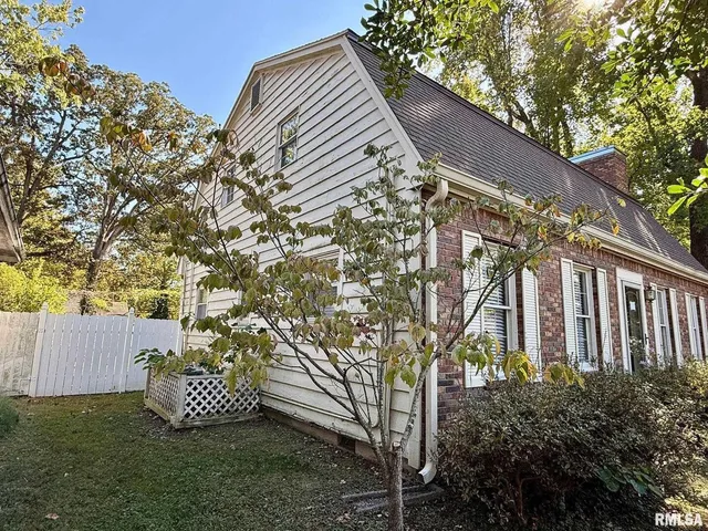 a view of a house with a yard and wooden fence