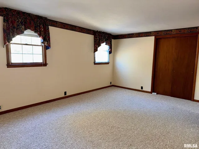en empty room with windows and ceiling fan