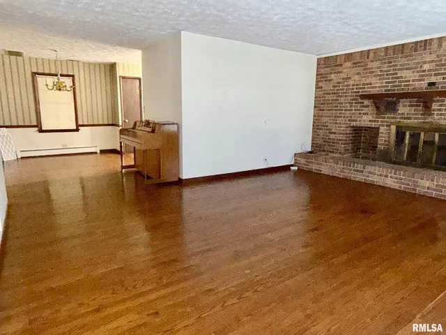 a view of a livingroom with wooden floor and a fireplace