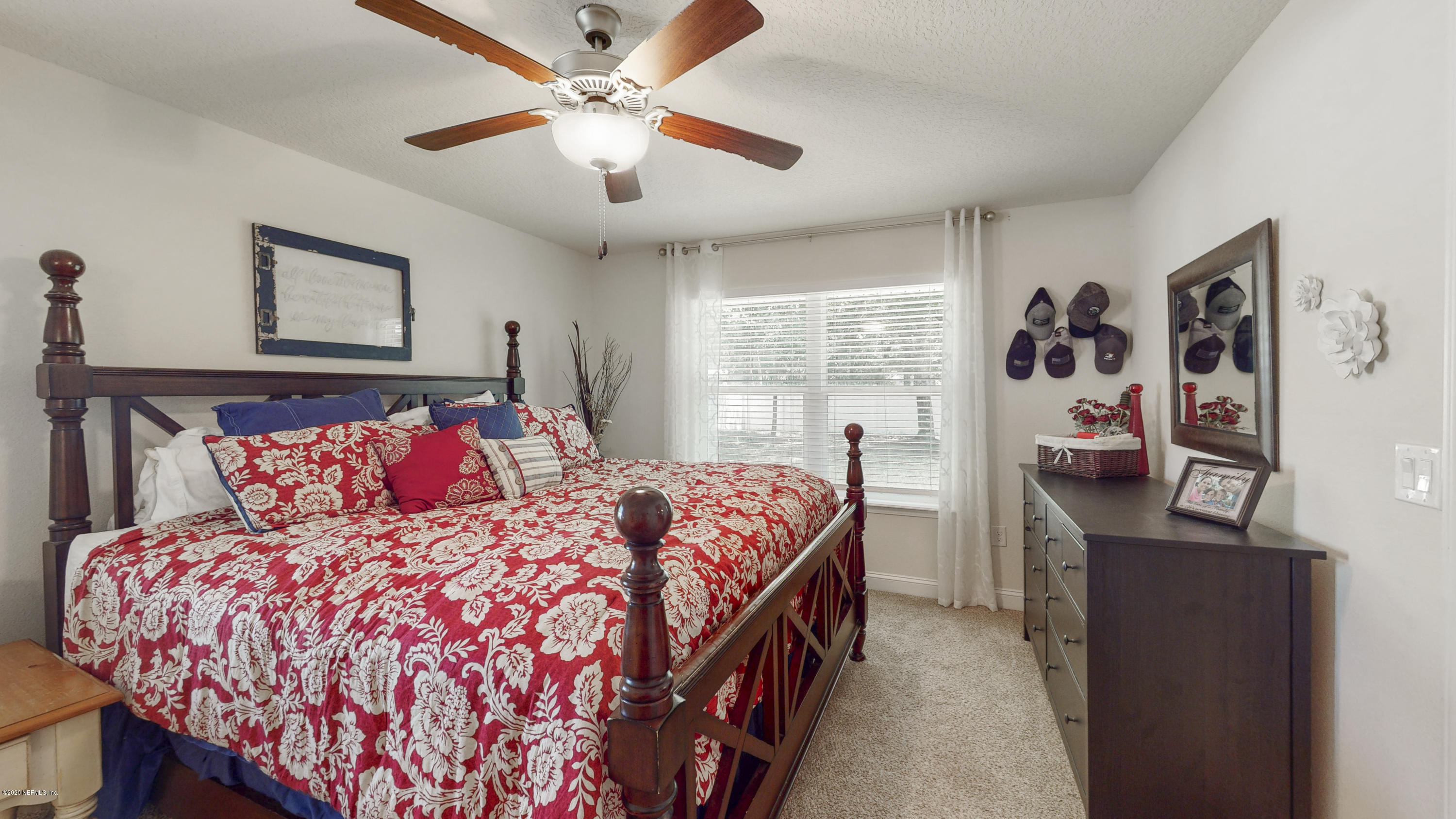 88101 Maybourne Road Yulee, FL 32097 - Photo 13 of 22 a bedroom with a large bed and a chandelier