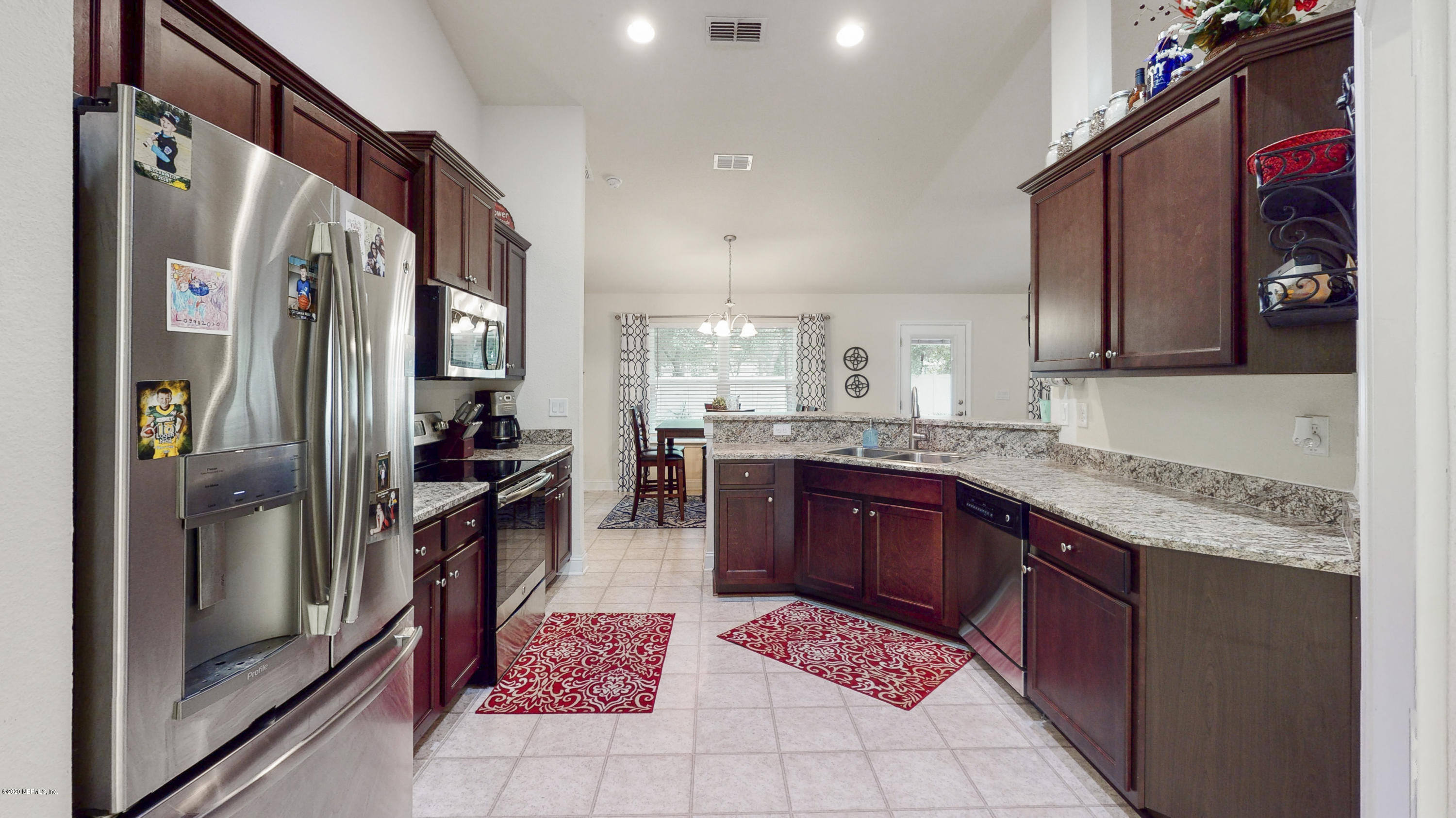 88101 Maybourne Road Yulee, FL 32097 - Photo 8 of 22 a kitchen with stainless steel appliances granite countertop a refrigerator and a sink