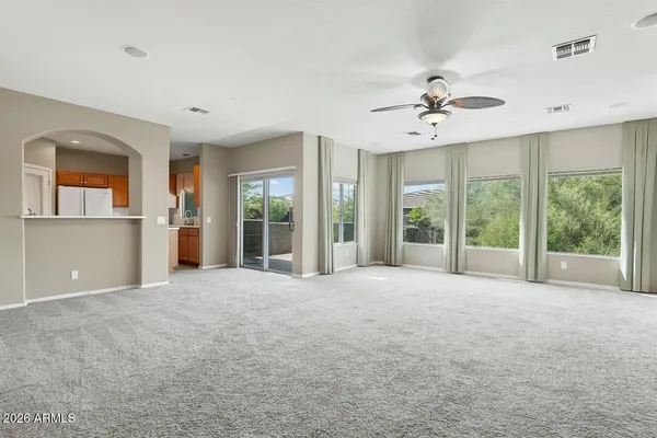 a view of an empty room with a window and a kitchen