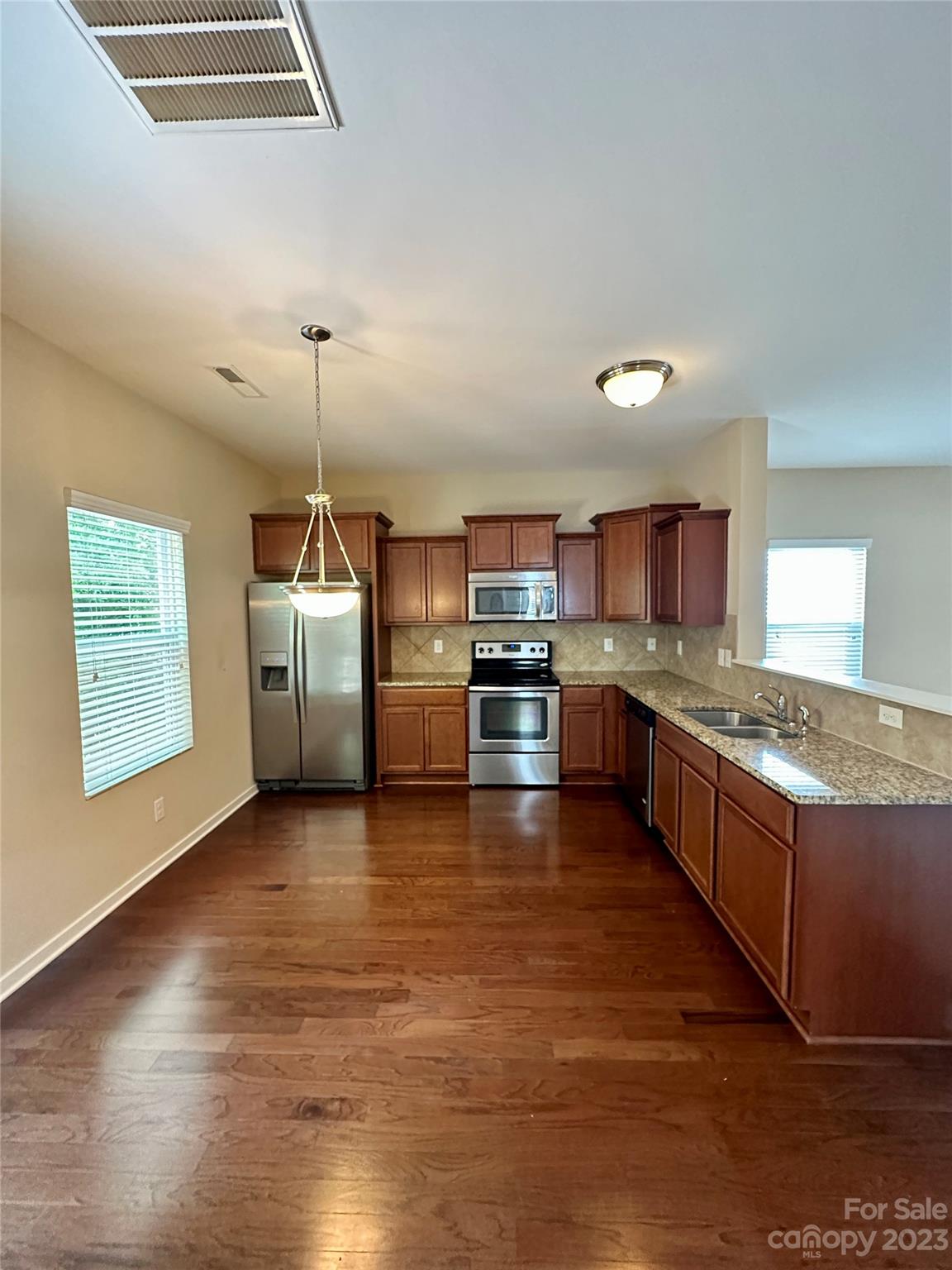 5513 Idlewild Road North Charlotte, NC 28227 - Photo 5 of 18 a large kitchen with stainless steel appliances granite countertop a stove and a wooden floors