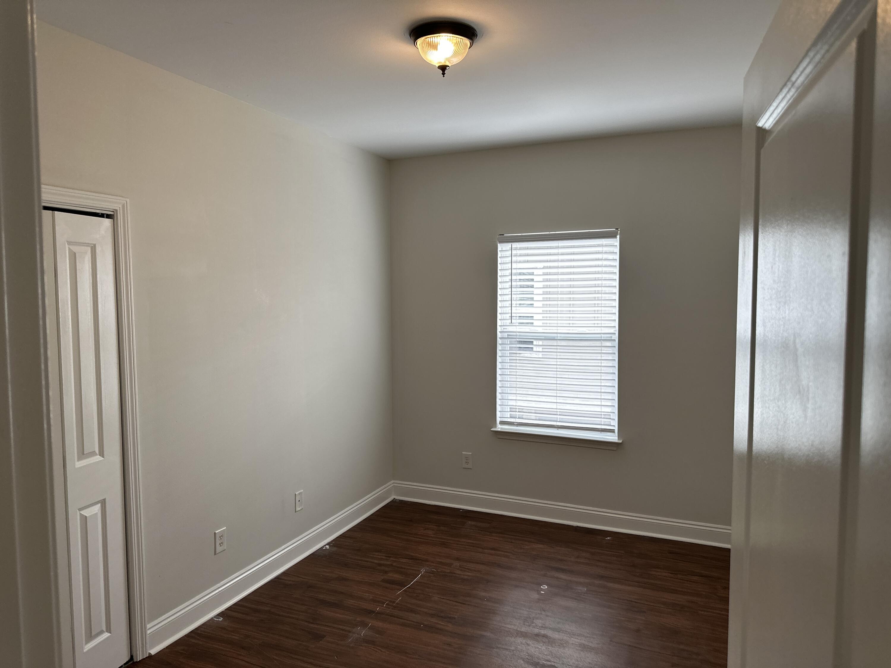 261 County Line Road Niceville, FL 32578 - Photo 11 of 17 an empty room with wooden floor and windows