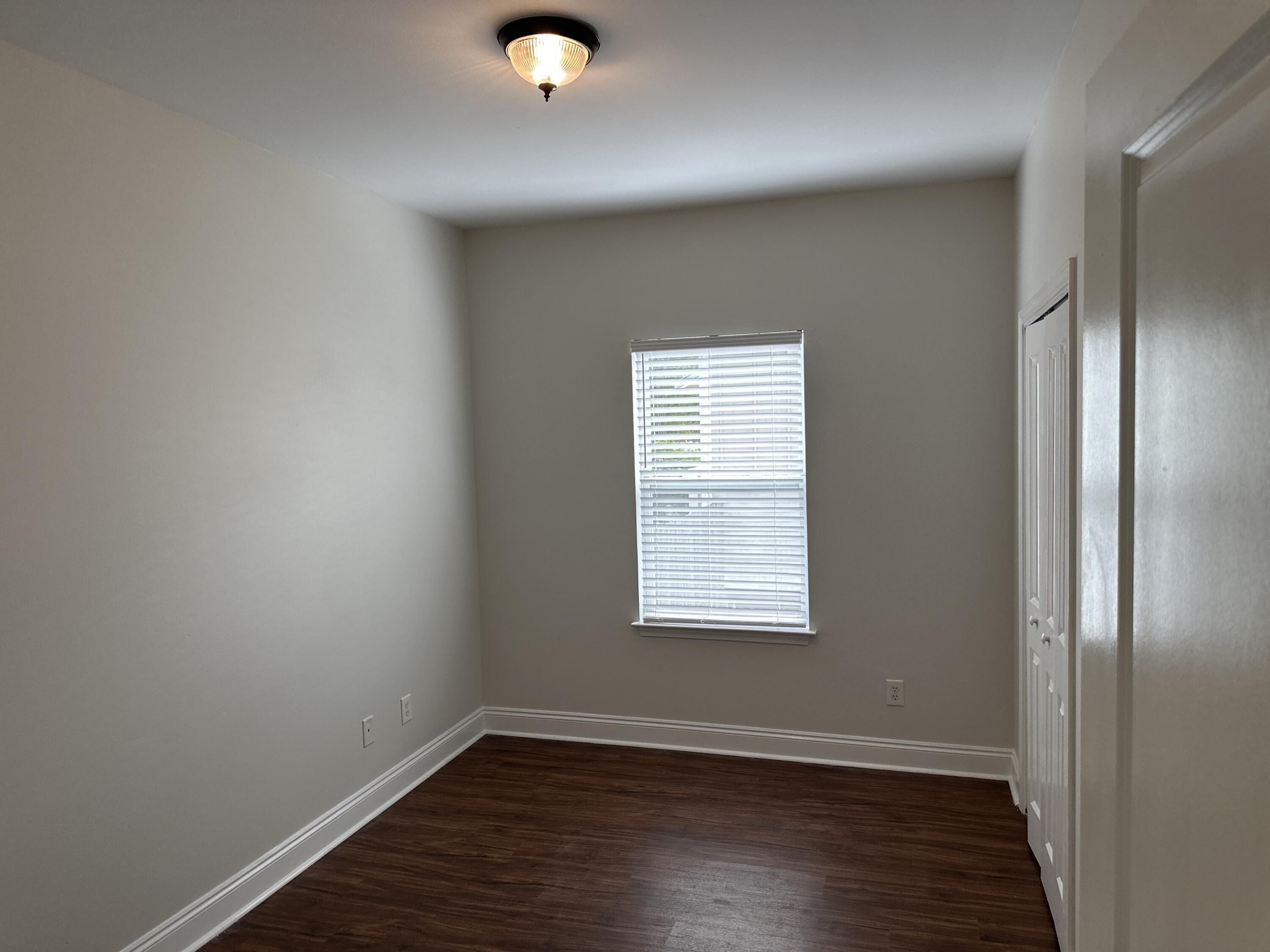 261 County Line Road Niceville, FL 32578 - Photo 13 of 17 an empty room with wooden floor and windows