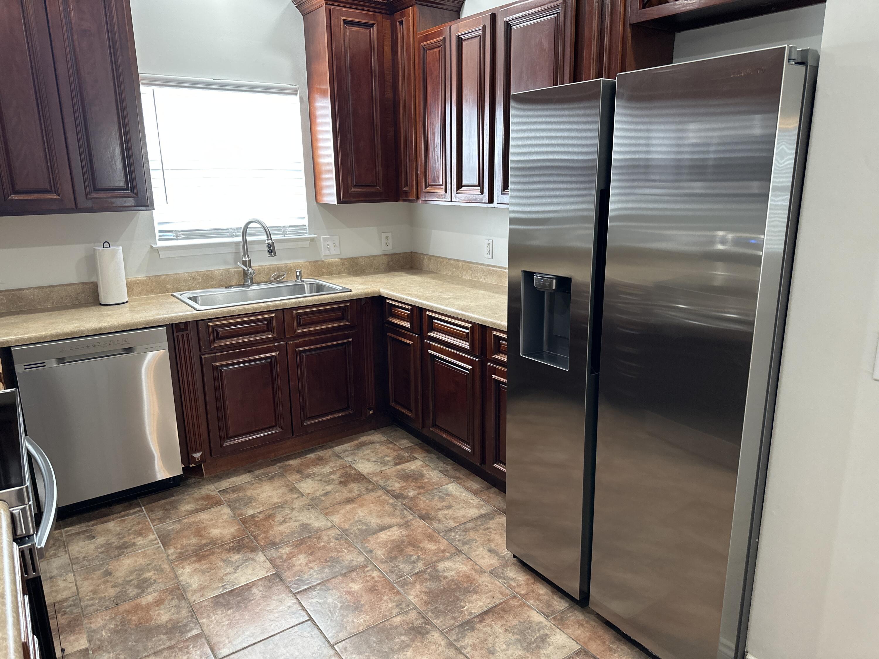 261 County Line Road Niceville, FL 32578 - Photo 16 of 17 a kitchen with a sink refrigerator and cabinets