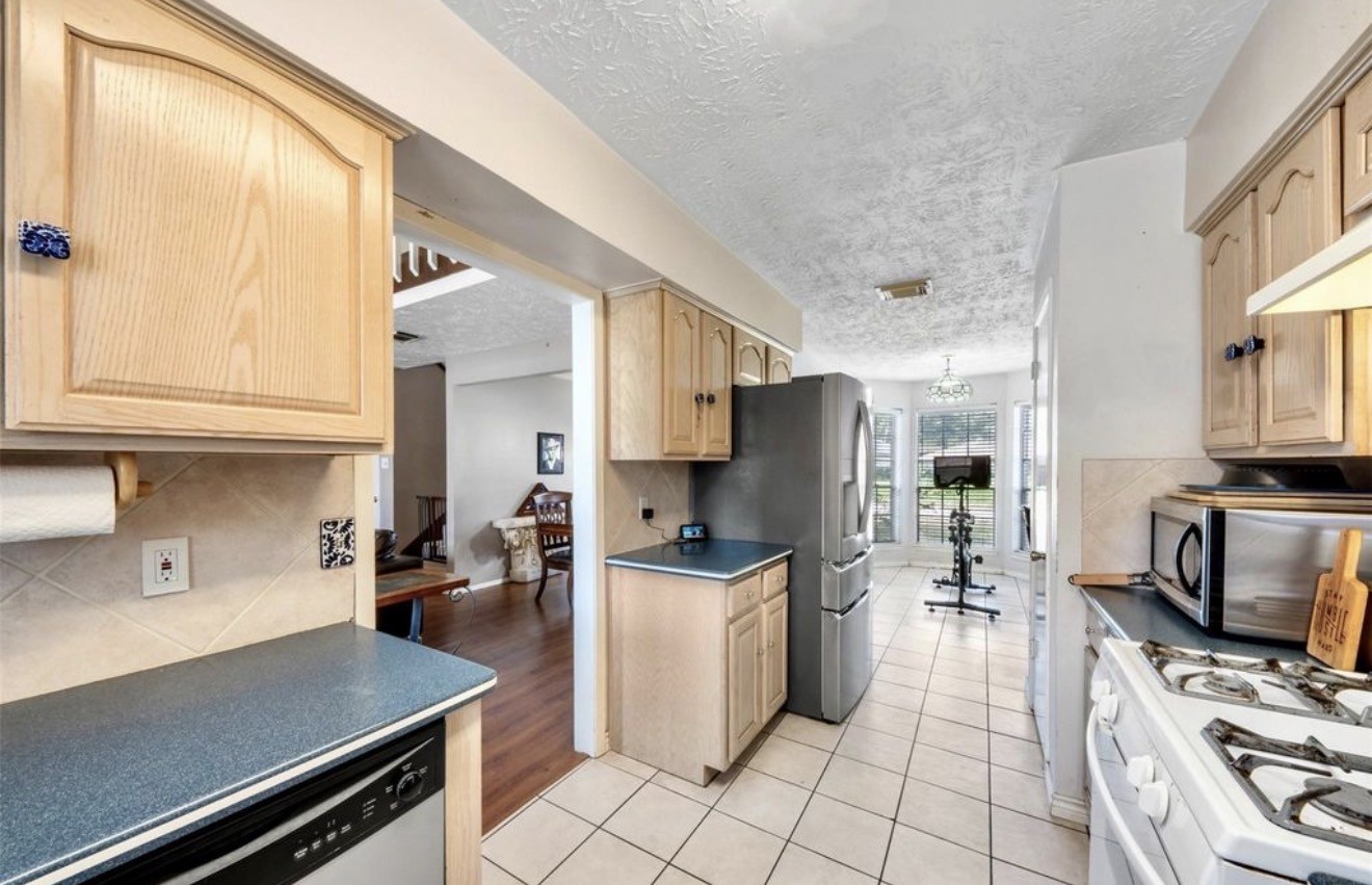 17314 Edenbridge Court Spring, TX 77379 - Photo 13 of 33 a kitchen with stainless steel appliances a stove a sink and a refrigerator