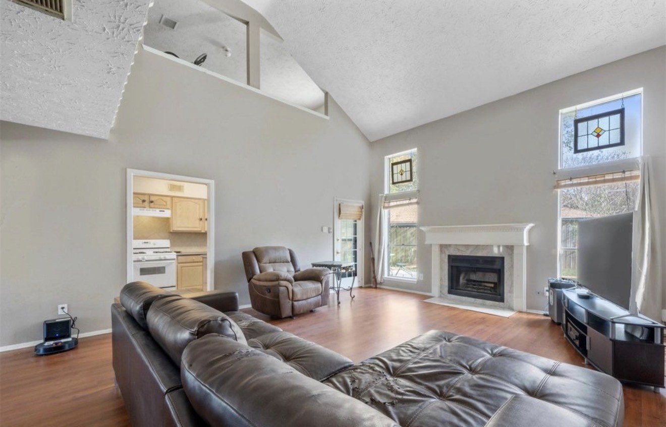 17314 Edenbridge Court Spring, TX 77379 - Photo 16 of 33 a living room with furniture large window and a fireplace