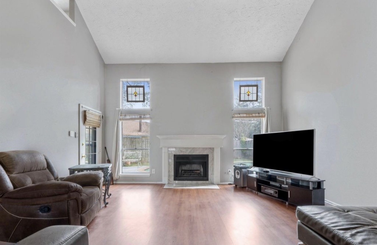 17314 Edenbridge Court Spring, TX 77379 - Photo 9 of 33 a living room with furniture a flat screen tv and a fireplace