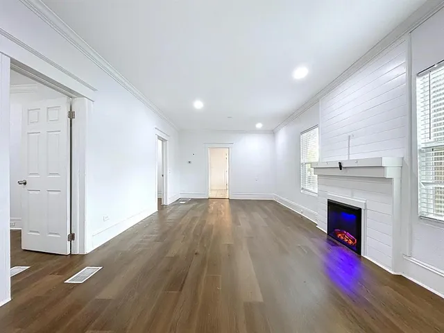 an empty room with wooden floor and fireplace