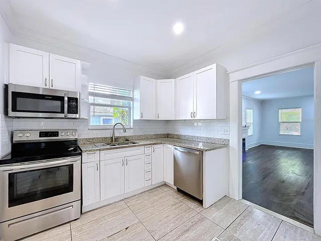 a kitchen with sink a microwave and cabinets