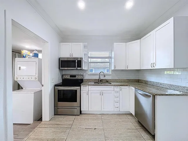 a kitchen with stainless steel appliances granite countertop a stove top oven a sink and dishwasher
