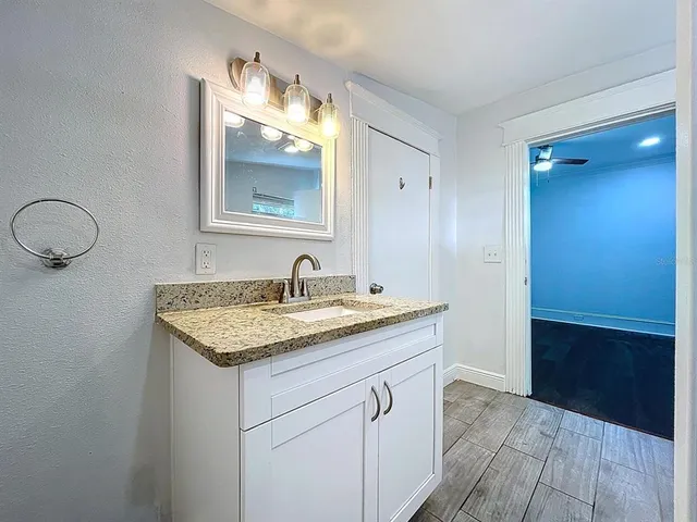a bathroom with a granite countertop sink and a mirror