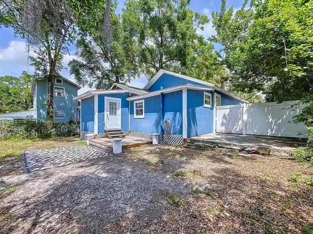 a view of a house with a yard and large tree