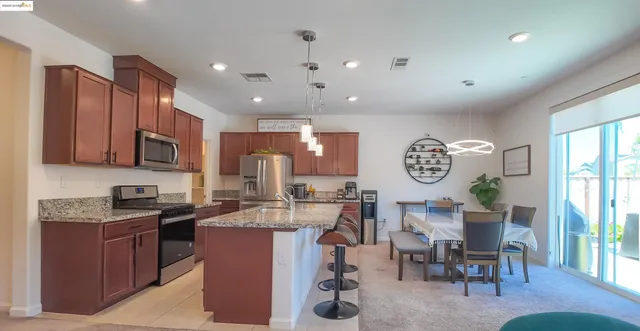 a kitchen with a table chairs and a refrigerator