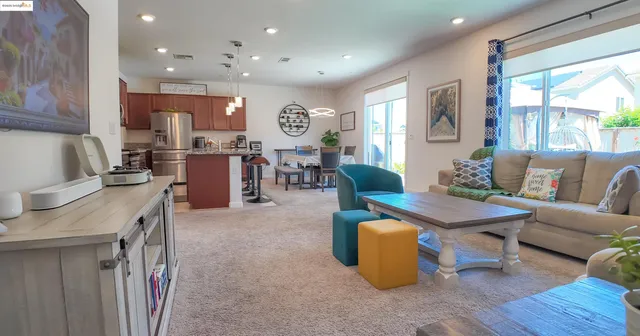 a living room with furniture kitchen view and a large window