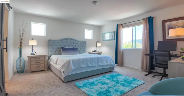 a bedroom with a bed and a lamp on dresser