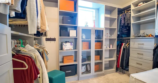 a view of walk in closet with clothes and shoes