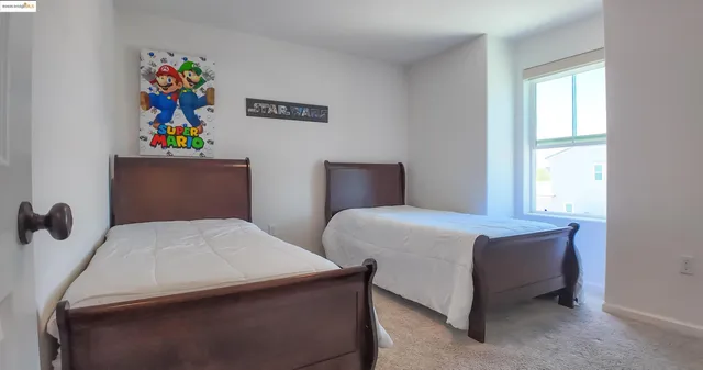 a bedroom with a bed and painting on the wall