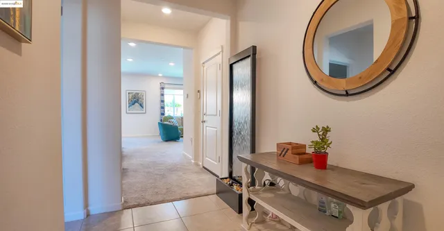 a view of a room that has a mirror and furniture