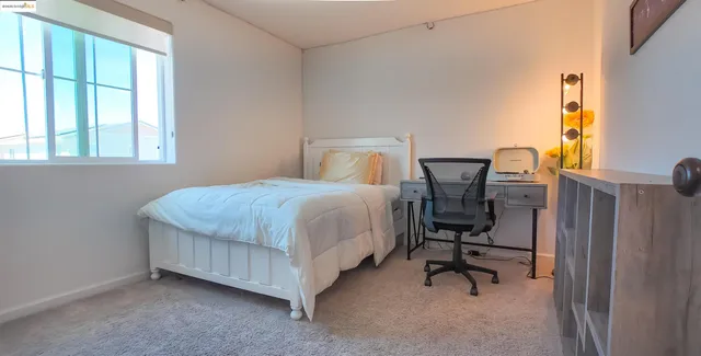 a bedroom with a bed chair and a window
