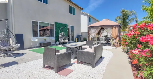 a view of a patio with couches table and chairs under an umbrella
