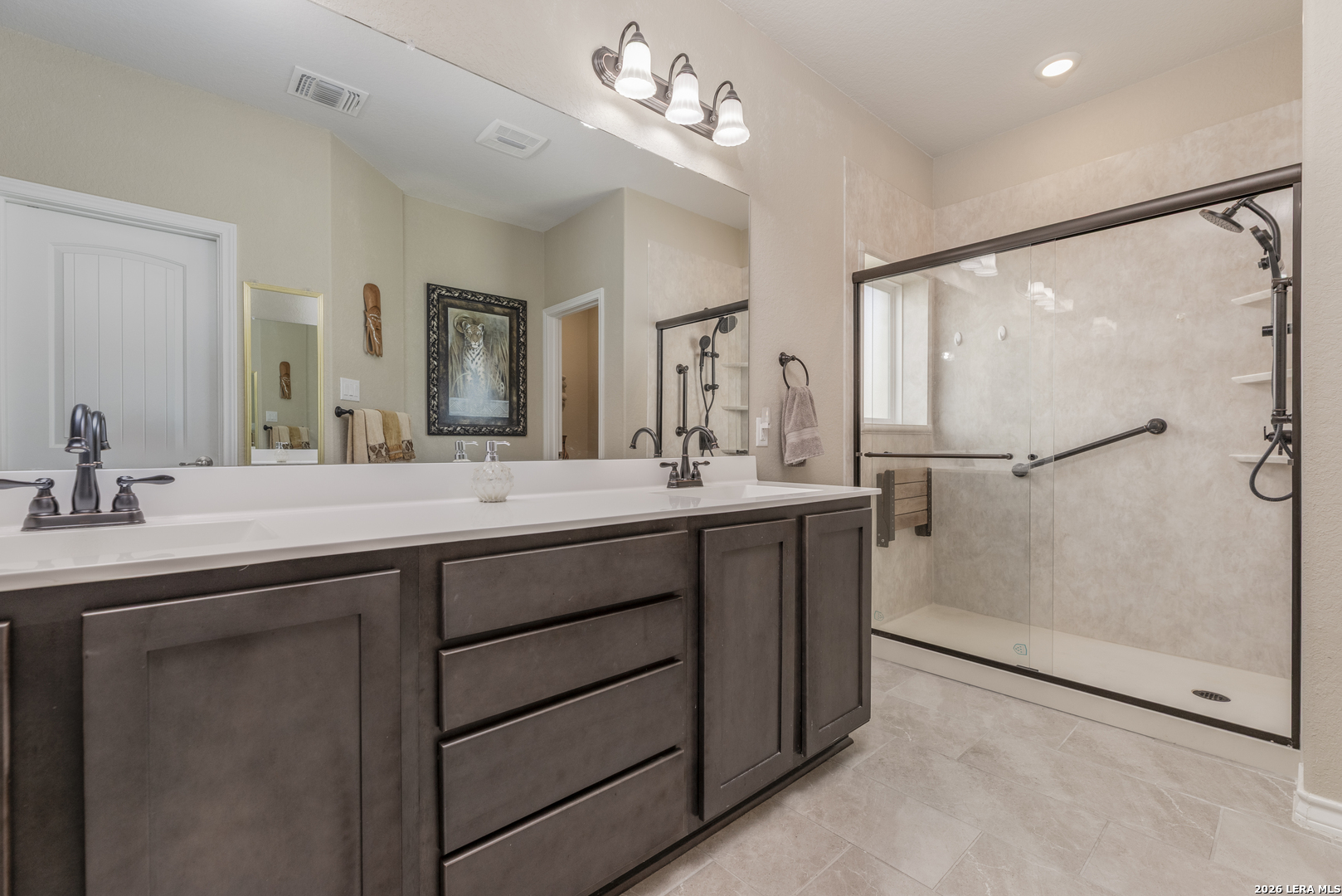 133 Grand View Floresville, TX 78114 - Photo 13 of 43 a bathroom with a double vanity sink a mirror and a shower