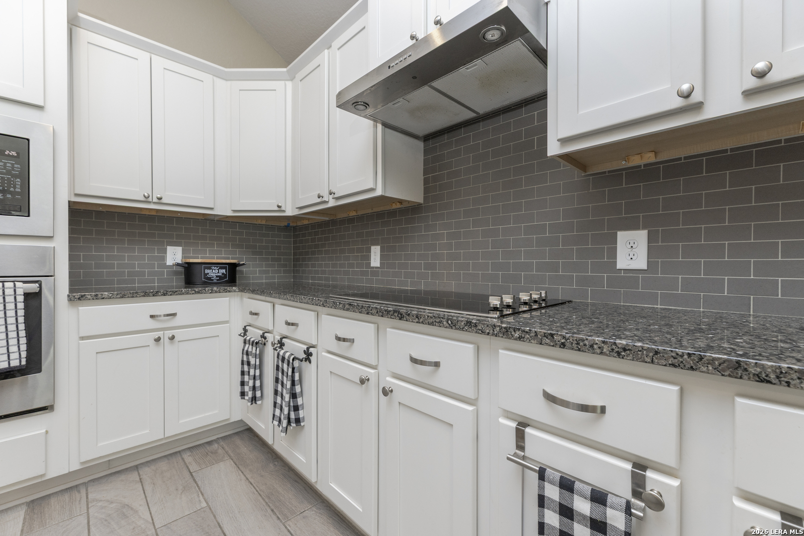 133 Grand View Floresville, TX 78114 - Photo 25 of 43 a kitchen with granite countertop white cabinets and white appliances