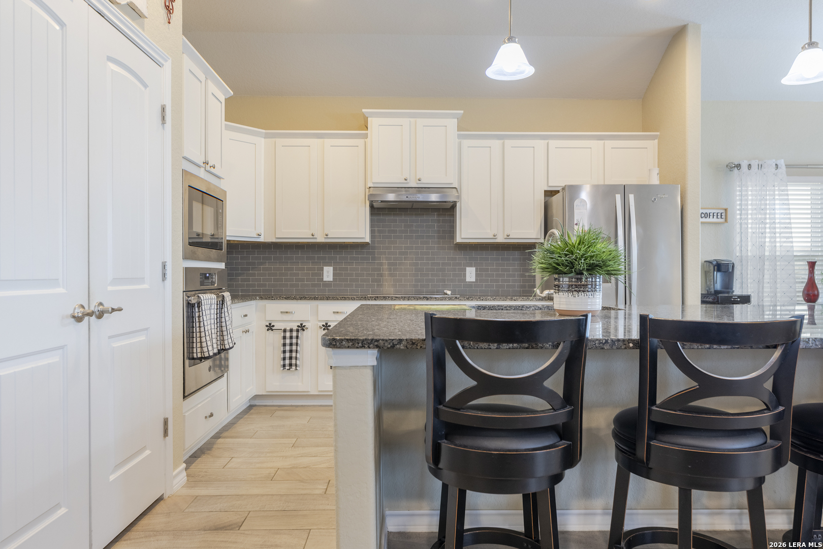 133 Grand View Floresville, TX 78114 - Photo 26 of 43 a kitchen with stainless steel appliances granite countertop a table chairs in it and wooden floors