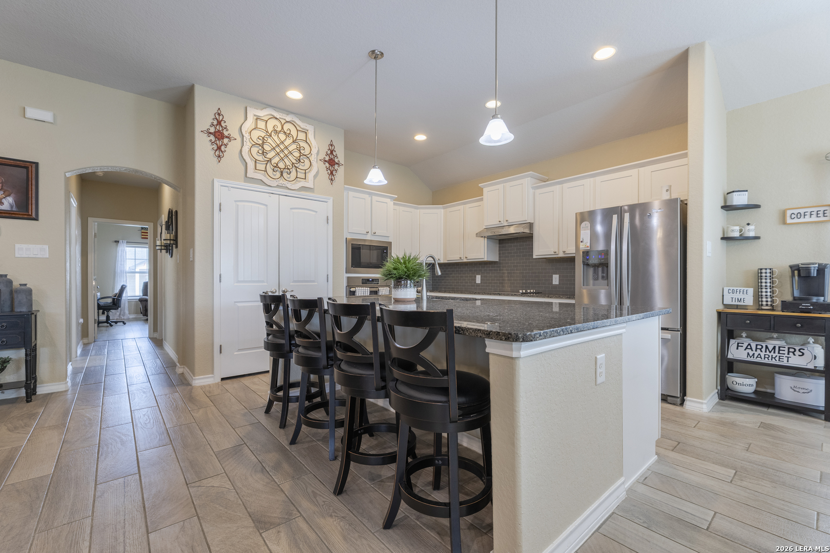 133 Grand View Floresville, TX 78114 - Photo 28 of 43 a kitchen with stainless steel appliances kitchen island granite countertop a dining table chairs refrigerator and sink