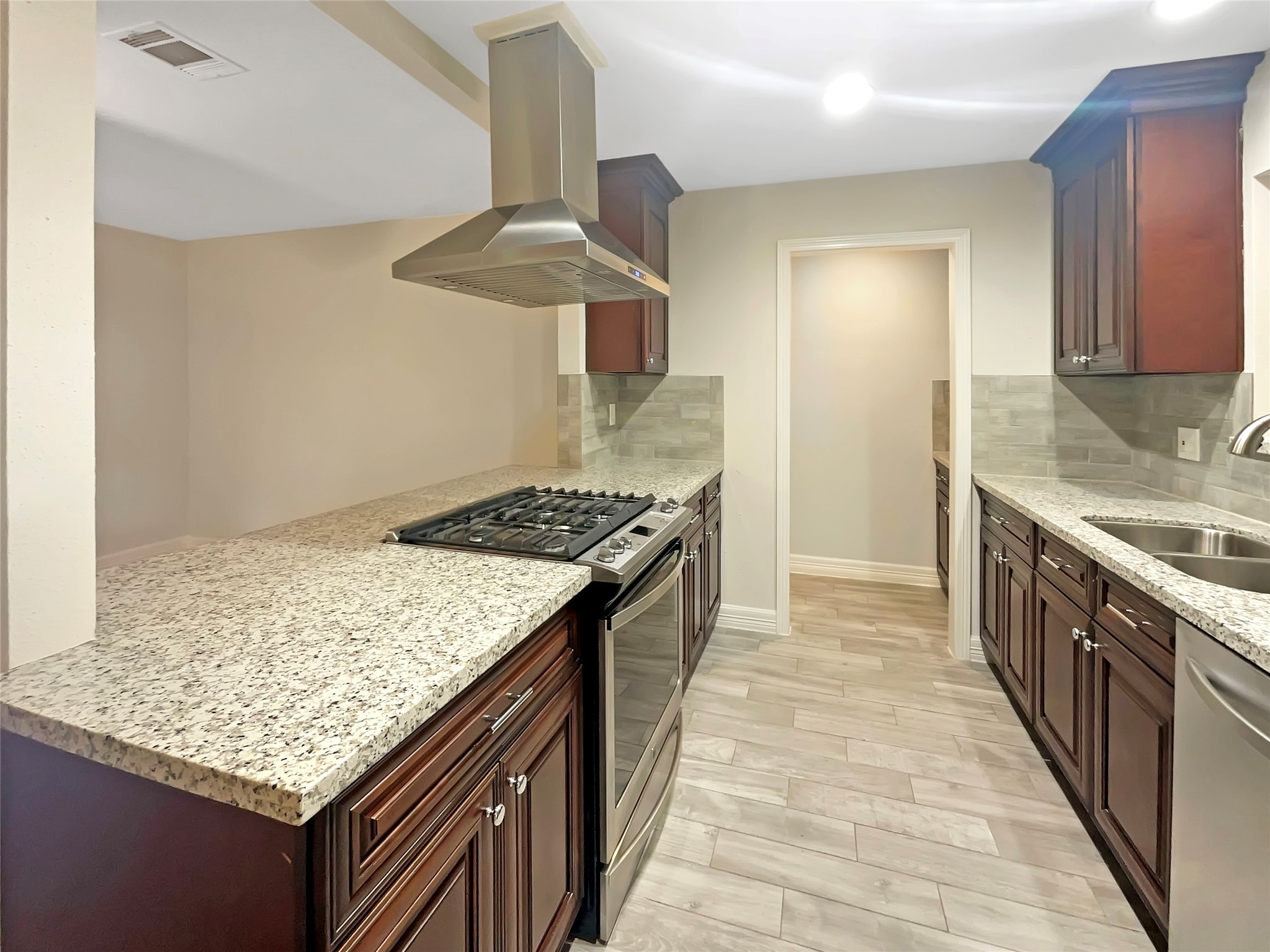 12107 Pompton Drive Houston, TX 77089 - Photo 12 of 23 a kitchen with a stove and a wooden floor