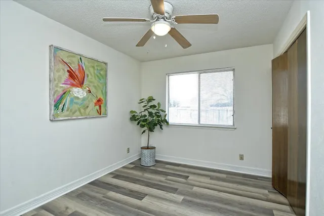 an empty room with window and ceiling fan