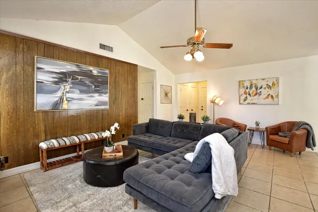 a living room with furniture ceiling fan and a rug