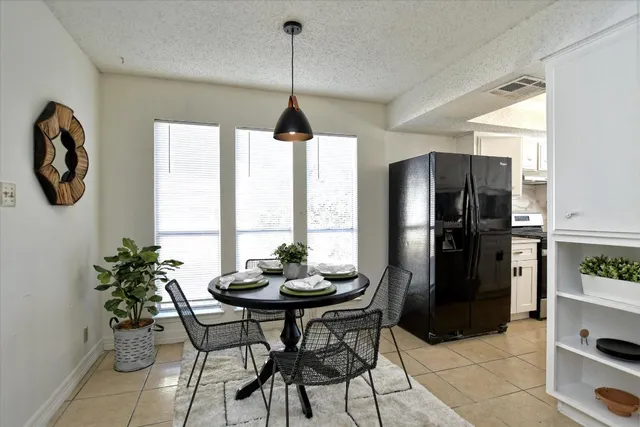a kitchen with a refrigerator a table and chairs in it