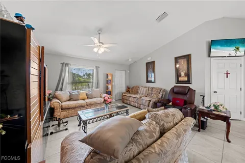 a living room with furniture a large window and a flat screen tv