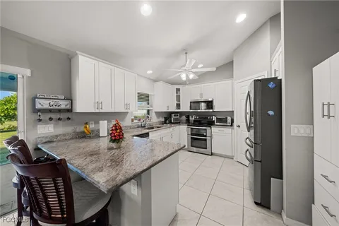 a kitchen with stainless steel appliances granite countertop a stove refrigerator sink and cabinets
