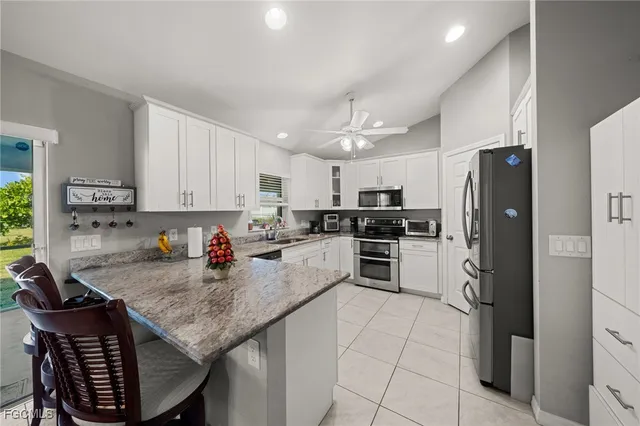 a kitchen with stainless steel appliances granite countertop a stove refrigerator sink and cabinets