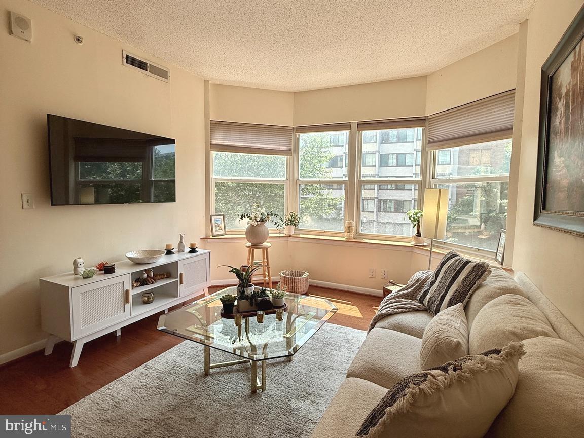 1111 11th Street Northwest, Unit 304 Washington, DC 20001 - Photo 4 of 27 a living room with furniture a flat screen tv and a large window