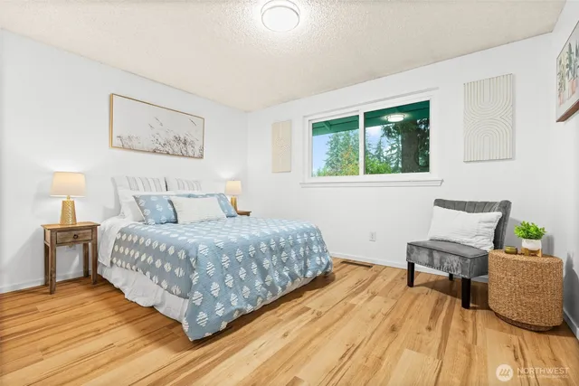 a bedroom with a bed and wooden floor