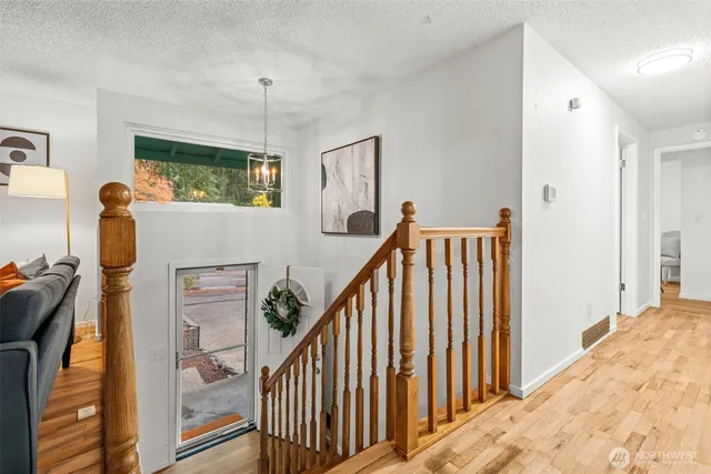 a view of a hallway with wooden floor and staircase