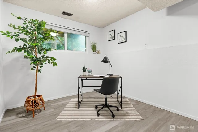 a view of workspace filled with furniture and wooden floor