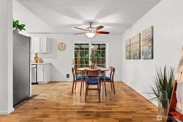 a dining room with wooden floor a chandelier a glass table and chairs